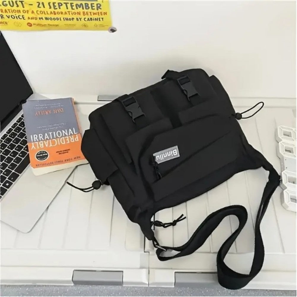 Black bag on a desk with a laptop and books
