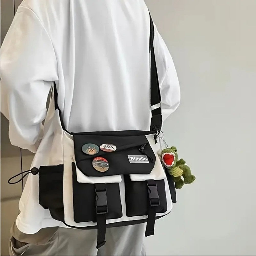 Person wearing a black and white bag with colorful buttons and a small plush toy on a plain background